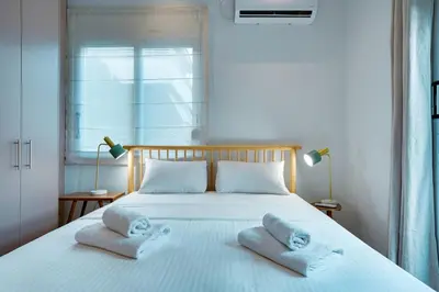a bedroom with a white bed with towels on it at Garden Level Gem in the City in Athens