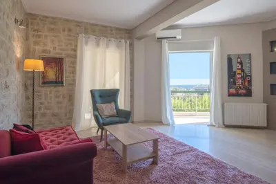 a living room with a couch and a chair at Modern Greek Escape close to Alimos Shore in Athens