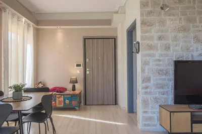 a living room with a table and a room with a bedroom at Modern Greek Escape close to Alimos Shore in Athens