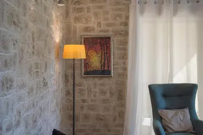 a lamp in a room with a chair and a wall at Modern Greek Escape close to Alimos Shore in Athens