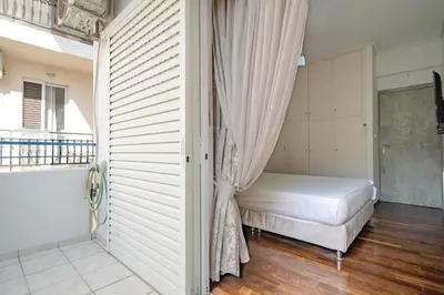 a bedroom with a bed and a curtain at Barbara's sweet home Glyfada by ΜΡS in Athens
