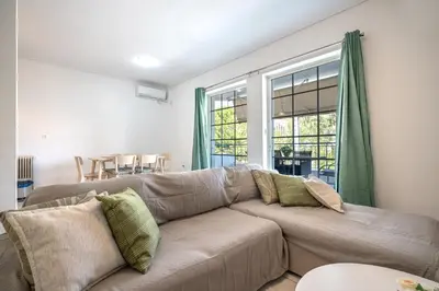 a living room with a brown couch and a table at Barbara's sweet home Glyfada by ΜΡS in Athens