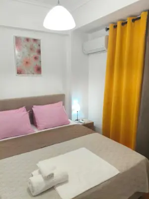 a bedroom with a bed with pink and yellow curtains at Sofia's Beauty apartments in Athens