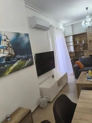 a living room with a flat screen tv on a wall at Sofia's Beauty apartments in Athens