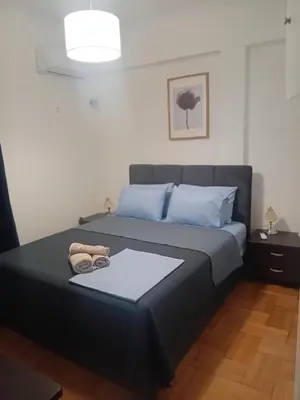 a bedroom with a black bed with blue pillows at Sofia's Beauty apartments in Athens