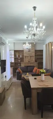 a living room with a couch and a chandelier at Sofia's Beauty apartments in Athens