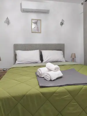 a green bed with two towels on top of it at Sofia's Beauty apartments in Athens
