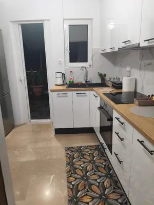 a kitchen with white cabinets and a counter top at Sofia's Beauty apartments in Athens