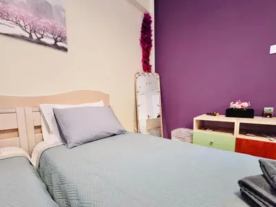 a bedroom with two beds and purple walls at Gaia Casa Athens in Athens