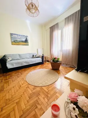 a living room with a couch and a wooden floor at Gaia Casa Athens in Athens