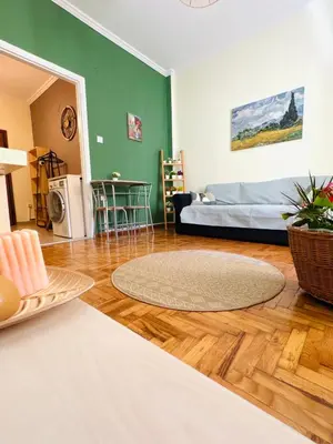 a living room with a bed and a wooden floor at Gaia Casa Athens in Athens