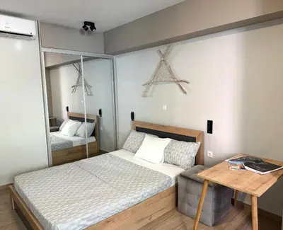 a small bedroom with a bed and a mirror at TAVROS suites in Athens