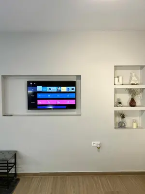 a television on a white wall in a room at TAVROS suites in Athens