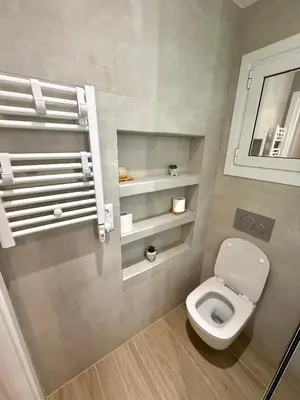 a bathroom with a white toilet and a mirror at TAVROS suites in Athens