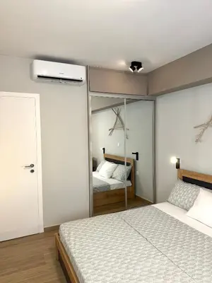 a bedroom with a bed and a mirror at TAVROS suites in Athens