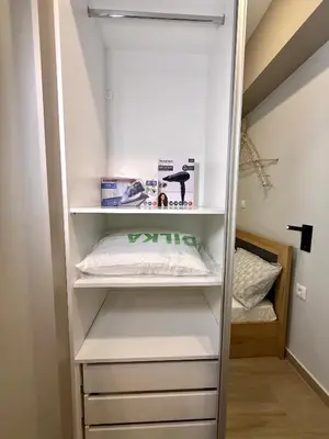 a walk in closet with white shelves at TAVROS suites in Athens