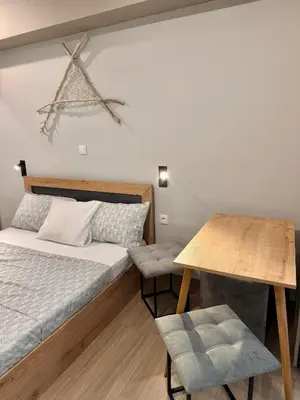 a small bedroom with a bed and a table at TAVROS suites in Athens