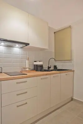a kitchen with white cabinets and a sink at Historic Boutique Apartment in Artists' Kipseli in Athens