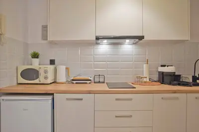 a kitchen with white cabinets and a microwave at Historic Boutique Apartment in Artists' Kipseli in Athens