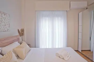 a bedroom with a white bed with a window at Historic Boutique Apartment in Artists' Kipseli in Athens