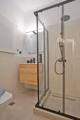 a bathroom with a shower with a sink and a toilet at Historic Boutique Apartment in Artists' Kipseli in Athens