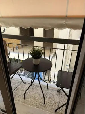 a table with a potted plant on a balcony at Historic Boutique Apartment in Artists' Kipseli in Athens