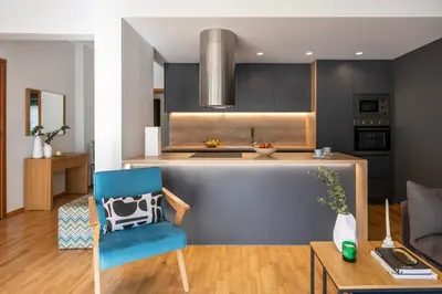 a kitchen with a blue chair in a room at Spacious 3-Bedroom Getaway with Balcony in Glyfada in Athens