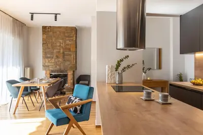 a kitchen and living room with a table and chairs at Spacious 3-Bedroom Getaway with Balcony in Glyfada in Athens
