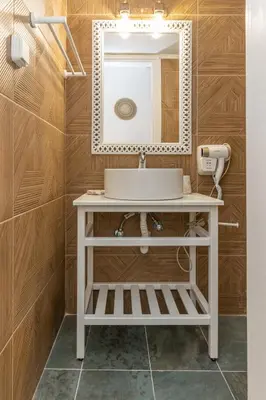 a bathroom with a white sink and a mirror at Hillside Suite Athens in Athens