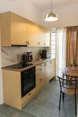 a kitchen with yellow cabinets and a table with a dining room at Hillside Suite Athens in Athens