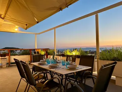 a table and chairs on a patio with a view at Panoramic Penthouse in Athens