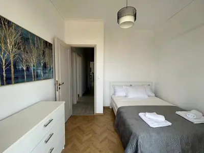 a bedroom with two beds and a painting on the wall at Panoramic Penthouse in Athens