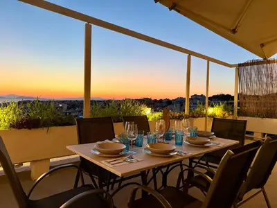 a table on a balcony with a view of the sunset at Panoramic Penthouse in Athens
