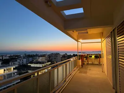 a balcony with a view of the city at sunset at Panoramic Penthouse in Athens