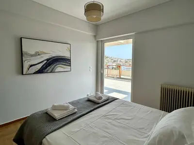 a bedroom with a bed and a large window at Panoramic Penthouse in Athens