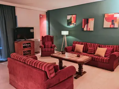 a living room with two red couches and a television at Minimal Vintage διαμέρισμα στο κέντρο της Αθήνας in Athens