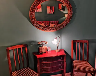 a mirror above a red dresser and two chairs at Minimal Vintage διαμέρισμα στο κέντρο της Αθήνας in Athens