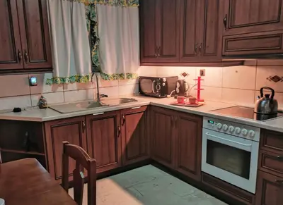 a kitchen with wooden cabinets and a stove top oven at Minimal Vintage διαμέρισμα στο κέντρο της Αθήνας in Athens