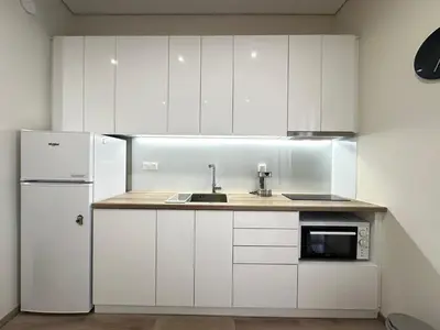 a white kitchen with a sink and a refrigerator at Athens 5th Floor Retreat, Blissful Escape in Athens