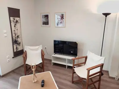 a living room with two chairs and a television at Athens 5th Floor Retreat, Blissful Escape in Athens