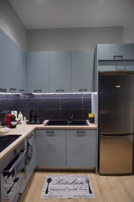 a kitchen with white cabinets and a stainless steel refrigerator at The Urban Nest 1 in Athens