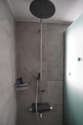 a shower with a shower head in a bathroom at The Urban Nest 1 in Athens