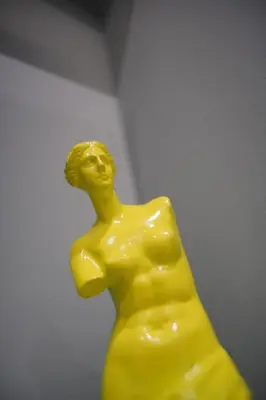 a yellow statue of a woman with her head up at The Urban Nest 1 in Athens
