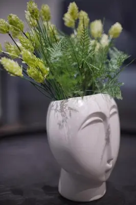 a white vase with flowers in it at The Urban Nest 1 in Athens