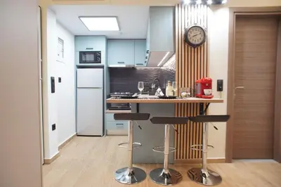 a kitchen with a counter and a clock on the wall at The Urban Nest 2 in Athens