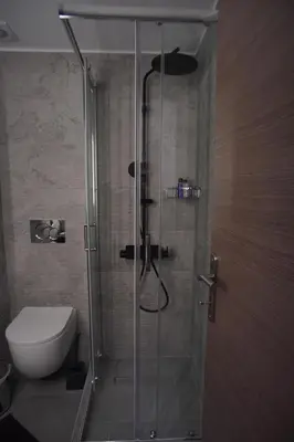 a bathroom with a glass shower with a toilet at The Urban Nest 2 in Athens
