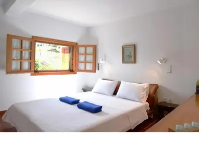 a bedroom with a bed with two blue pillows on it at Villa Falmy in Anavissos