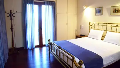 a bedroom with a large bed and a large window at Villa Falmy in Anavissos