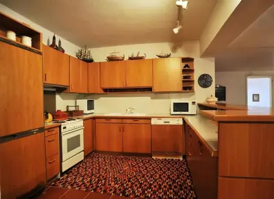 a kitchen with wooden cabinets and white appliances at Villa Falmy in Anavissos