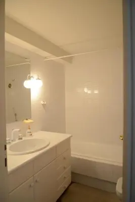 a white bathroom with a sink and a bath tub at Villa Falmy in Anavissos